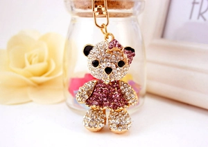 Detailed macro view of a crystal teddy bear keychain with purple rhinestones and gold alloy