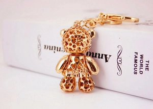 Macro shot of a golden crystal bear keychain with rhinestone inlay on a book
