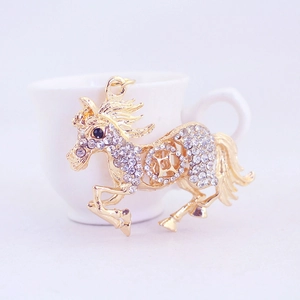 Porte-clés cheval au galop avec cristaux blancs et placage à l'or sur fond blanc