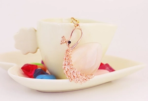Detailaufnahme vom pfauenförmigen Schlüsselanhänger in Roségold mit rosa Edelstein