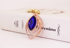 Macro detail of marquise-cut blue crystal pendant with pave rhinestones in rose gold