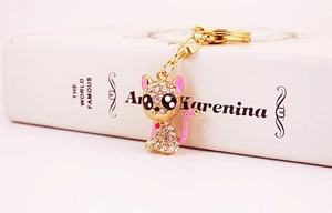 Detail view of sparkling gold crystal cat keychain with pink enamel accents and lobster clasp