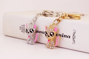 Detailed shot of sitting cat keychains with sparkling white rhinestones in gold and silver