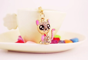 Close-up of a sparkling sitting cat keychain with crystal rhinestones and pink enamel finish