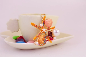 Détail du porte-clés étoile de mer avec perles et strass colorés sur une tasse