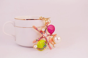 Détails du porte-clés étoile de mer à strass roses avec coquillages et perles