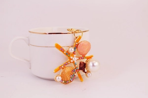 Détail de breloques étoile de mer et coquillage avec perles et strass multicolores