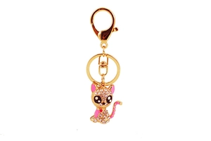 Close-up of sitting cat keychain with sparkling rhinestones and pink enamel accents
