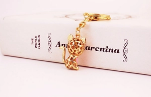 Close-up of golden kitten keychain with leopard print hollow design and shiny metal finish