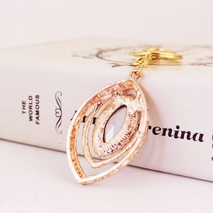 Peacock leaf keychain with rose gold plating, hollow layers and purple gemstone inlay