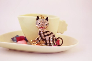 Détail d'un porte-clés chat porte-bonheur en métal doré avec strass étincelants