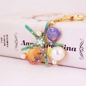 Porte-clés étoile de mer avec perles et strass colorés sur fond de livre décoratif
