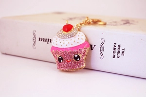 Detail of crystal cupcake keychain with pink rhinestones and a cute smiling face charm