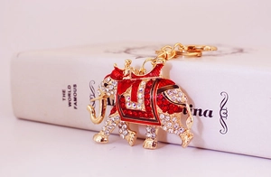 Close-up of golden elephant keychain with sparkling red and white rhinestones and enamel