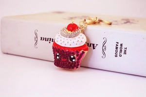 Detailed macro view of a crystal rhinestone cupcake keychain with a gold lobster clasp