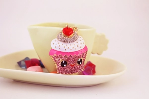 Detailed macro shot of a rhinestone cupcake keychain with pink crystals and a red cherry