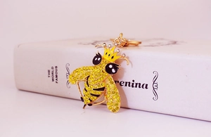 Dettaglio del portachiavi a forma di ape dorata con strass gialli e corona dorata