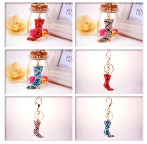 Detailed close-up of rhinestone high heel boot keychains in red, blue, and silver colors