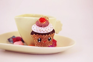 Detailed view of a sparkling rhinestone cupcake keychain with a cute face and cherry top