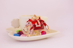Close-up of golden elephant keychain with sparkling rhinestones and red enamel details