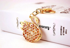 Detail view of golden swan keychain with hollow grid back and D-ring swivel clasp