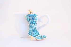 Detailed view of a golden boot keychain with intricate blue rhinestones for women