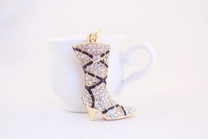Detailed close-up of a gold boot charm with sparkling rhinestones and black enamel accents