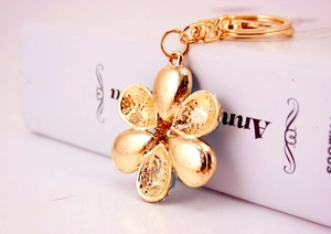Macro shot of gold floral keychain with detailed textured petals and polished lobster clasp