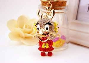 Detailed close-up of a golden dragon keychain featuring sparkling red and white rhinestones