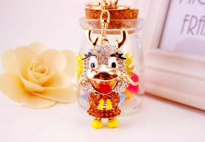 Detail of cute rhinestone dragon keychain with gold plating and enamel craftwork