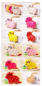 Gros plan des porte-clés mouton avec strass brillants et finitions en émail coloré