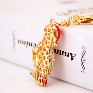 Porte-clés léopard doré avec design coeur ajouré et strass sur un livre blanc élégant