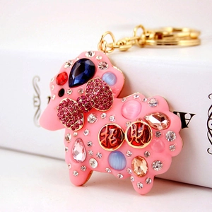 Sparkly pink sheep keychain with rhinestones and lucky coins on a white gift box