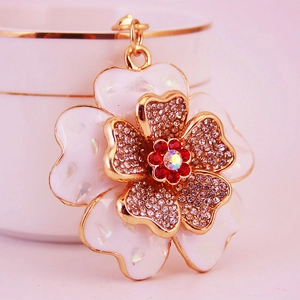 Detailed macro shot of layered shell and rhinestone peony pendant with gold metal edges