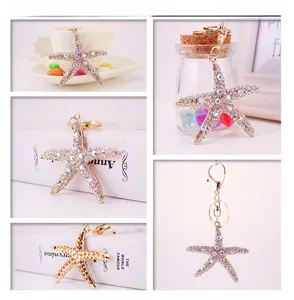 Detail view of crystal-encrusted starfish keychain with golden metal clasp and ring