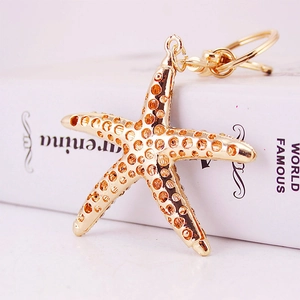 Creative gold starfish keychain with hollow polka dot texture and elegant metal link