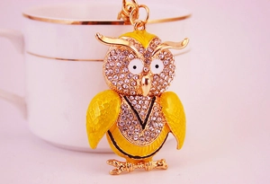 Detailed view of owl keychain with sparkling rhinestones and yellow enamel craft