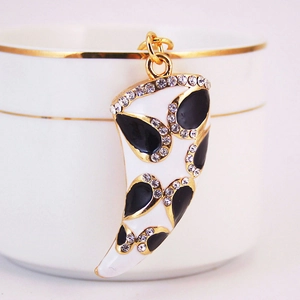 Vue détaillée d'un pendentif corne doré avec strass et finition en émail blanc