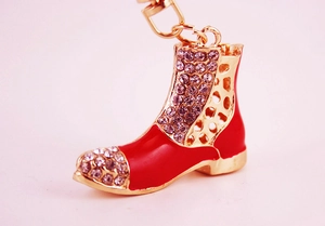 Detailed close-up of a red enamel high-heel boot keychain with purple rhinestones
