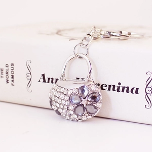Sparkling crystal handbag keychain with gray floral pattern on white background