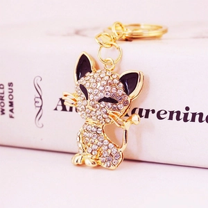 Sparkling crystal fox keychain with gold metal plating next to a classic white book