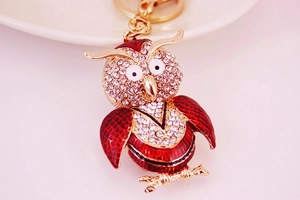 Macro shot of owl keychain with red enamel wings and sparkling inlaid crystal rhinestones