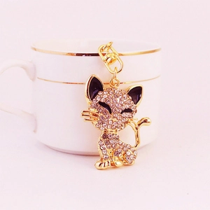 Sparkling crystal fox keychain with gold plating and rhinestones beside a coffee cup