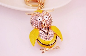 Detail of cute yellow owl keychain featuring sparkling rhinestones and golden lobster clasp