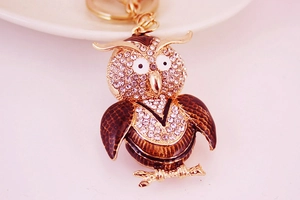 Detailed macro view of the rhinestone-studded owl keychain with brown enamel wings
