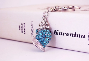 Detailed view of conch keychain featuring sparkling blue and white rhinestones