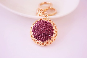 Vue détaillée du pendentif porte-clés en or rose serti de strass violets brillants