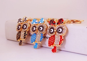 Détails de trois porte-clés chouette en strass colorés en bleu, rouge et imprimé léopard