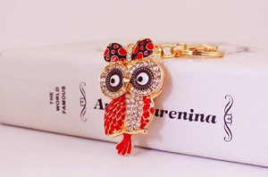 Détail de l'attache porte-clés hibou avec strass blancs et nœud papillon en émail rouge