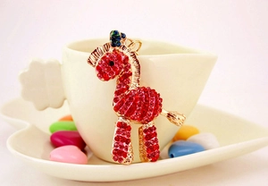 Dettaglio del portachiavi a forma di zebra con strass rossi e rosa su base metallica dorata